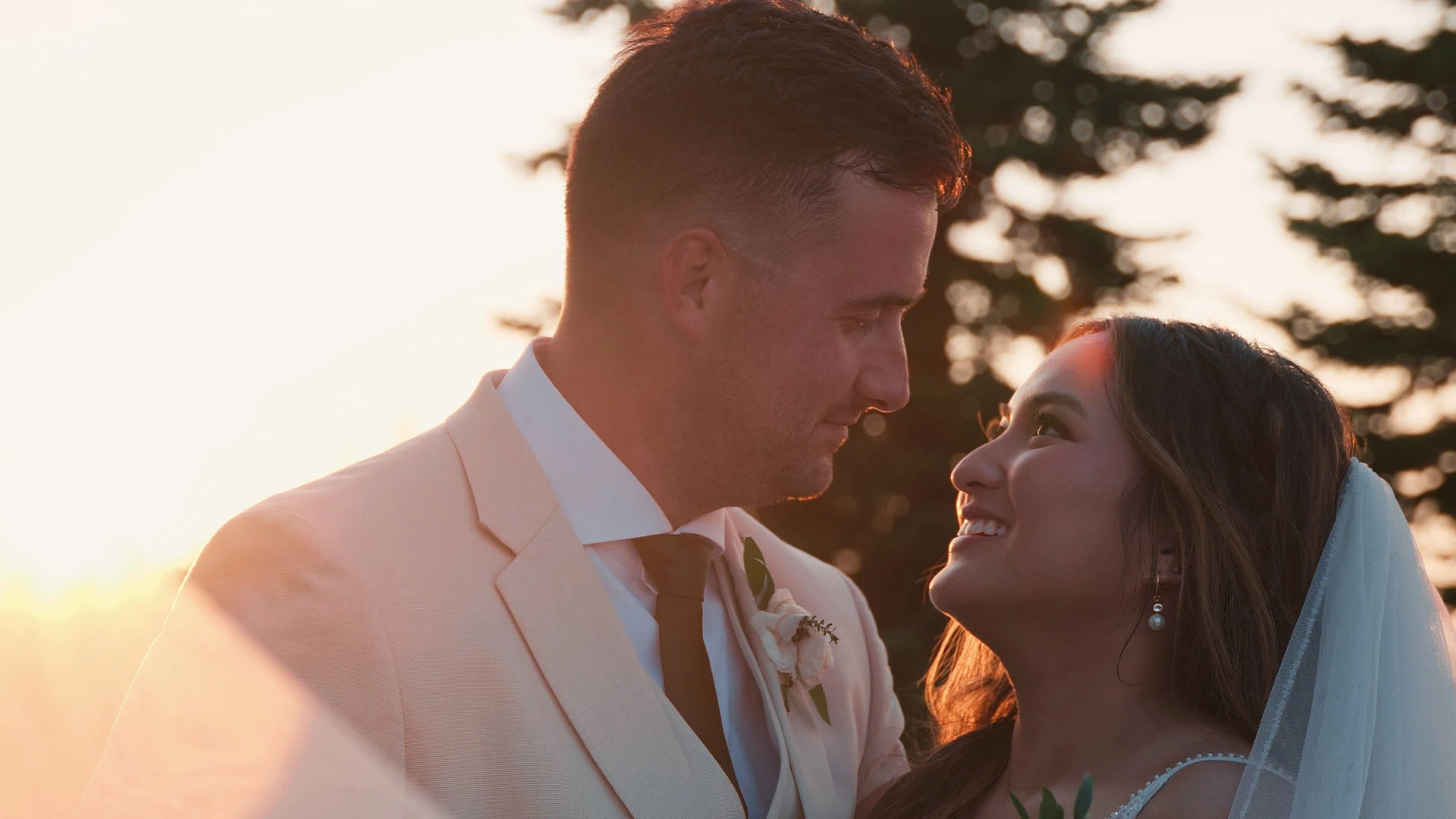 Cheska and Parker smiling at each other in golden sunset light at their Montana wedding