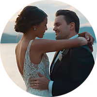 Allie and Henry smiling at each other at sunset by the water at their Montana wedding