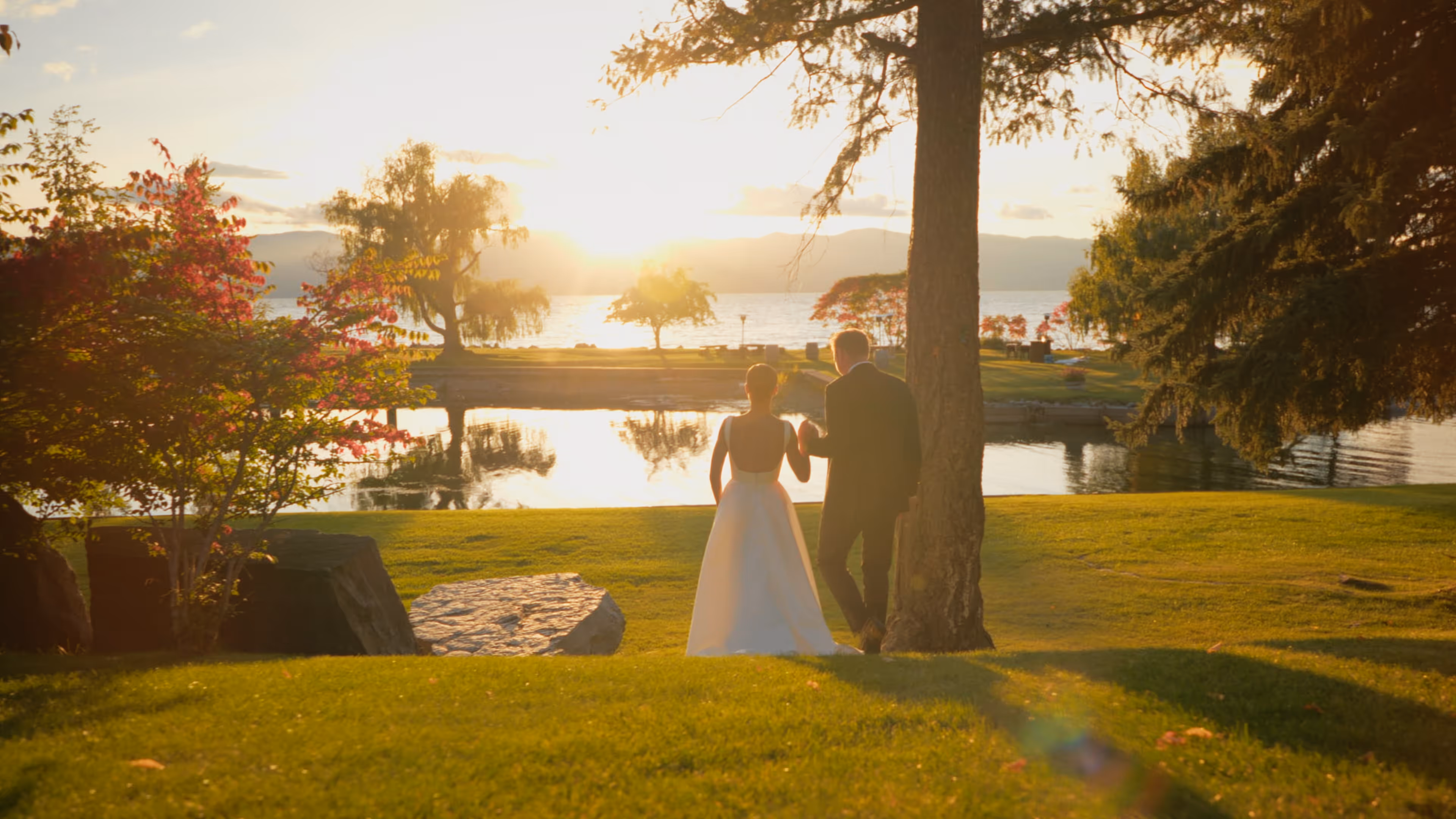 A couple looking out over the lake at sunset at their Bigfork Montana wedding